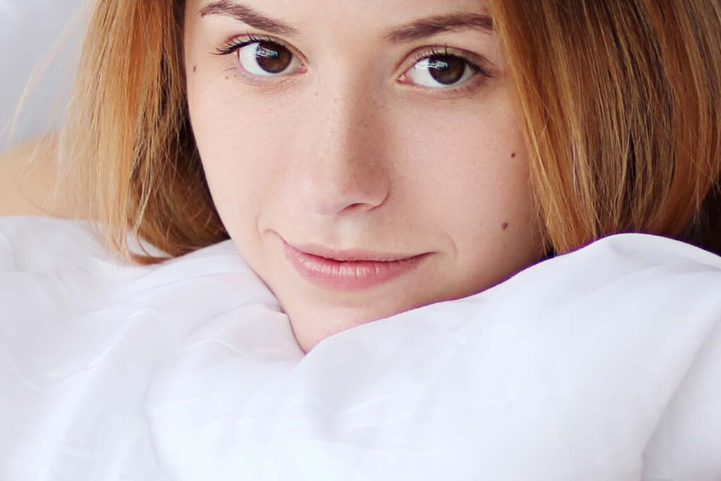 woman lying on bed with pillow